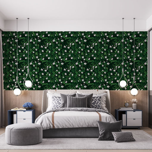 Une chambre moderne avec un papier peint floral sur fond vert foncé, orné de feuilles et de fleurs blanches, créant une atmosphère fraîche et vivante.