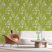 Un salon moderne avec un papier peint floral vert olive orné de délicates fleurs blanches, créant une atmosphère fraîche et apaisante.