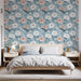 Une chambre lumineuse avec un papier peint floral bleu clair orné de grandes fleurs blanches et roses, créant une atmosphère douce et apaisante.