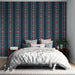 Une chambre élégante avec un papier peint bleu marine à motifs floraux rouges et blancs, créant une atmosphère romantique et chaleureuse.