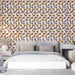 Une chambre moderne avec un papier peint floral aux motifs jaunes et bruns sur fond blanc, créant une atmosphère chaleureuse et accueillante.