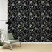 Un salon élégant avec un papier peint floral noir et beige aux motifs raffinés, créant une ambiance sophistiquée et chaleureuse.