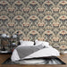Une chambre élégante avec un papier peint floral aux motifs vintage dans des teintes de rouge, bleu et beige, créant une atmosphère chaleureuse et raffinée.
