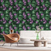 Un salon moderne avec un papier peint floral représentant des fleurs violettes sur fond vert foncé, créant une atmosphère tropicale et vivante.