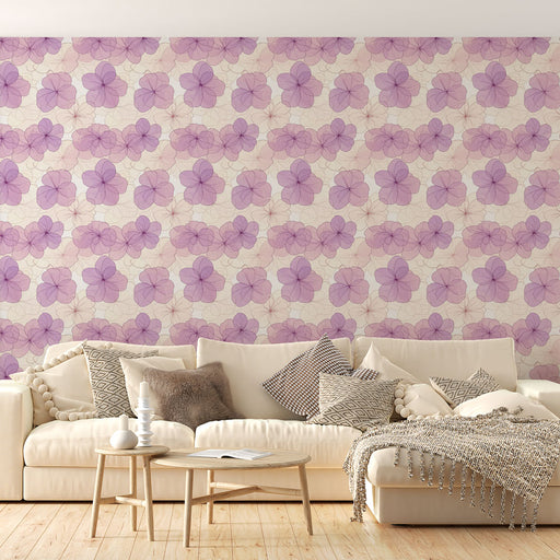Un salon lumineux avec un papier peint floral aux teintes violettes délicates sur fond beige, créant une atmosphère douce et apaisante.