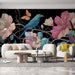 Un salon moderne avec un papier peint floral sur fond noir, représentant un oiseau coloré et de grandes fleurs aux teintes pastel, créant une atmosphère artistique et vivante.