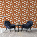 Un salon contemporain avec un papier peint floral sur fond terracotta, orné de grandes fleurs blanches et de délicates branches, créant une atmosphère chaleureuse et accueillante.