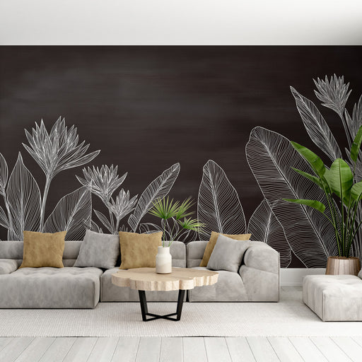 Un salon moderne avec un papier peint noir orné de dessins de plantes blanches, créant une atmosphère élégante et apaisante.