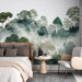 Une chambre apaisante avec un papier peint représentant une forêt brumeuse aux nuances de vert et de bleu, créant une atmosphère naturelle et sereine.