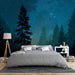 Une chambre moderne avec un papier peint représentant une forêt étoilée dans des teintes de bleu profond, créant une atmosphère apaisante et rêveuse.