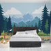 Une chambre moderne avec un papier peint représentant des montagnes stylisées et des forêts verdoyantes sur fond bleu, créant une ambiance apaisante et naturelle.