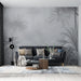 Un salon contemporain avec un papier peint tropical en nuances de gris représentant des feuillages luxuriants, créant une atmosphère apaisante et élégante.