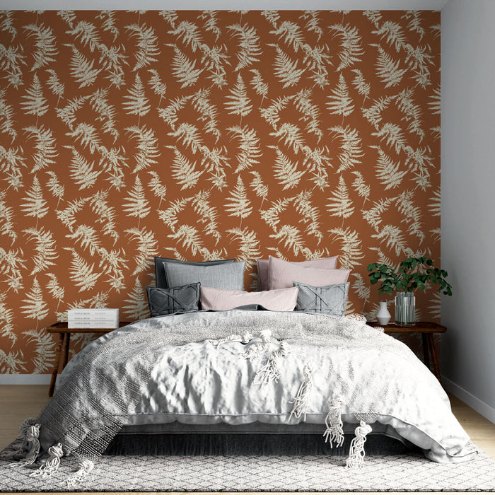 Une chambre accueillante avec un papier peint terracotta orné de motifs de fougères blanches, créant une atmosphère chaleureuse et naturelle.