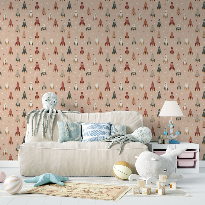 Un salon enfantin avec un papier peint ludique illustrant des fusées colorées sur un fond rose, créant une atmosphère joyeuse et imaginative.