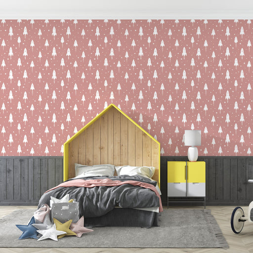 Une chambre d'enfant avec un papier peint rose aux motifs de fusées blanches, créant une ambiance ludique et imaginative.