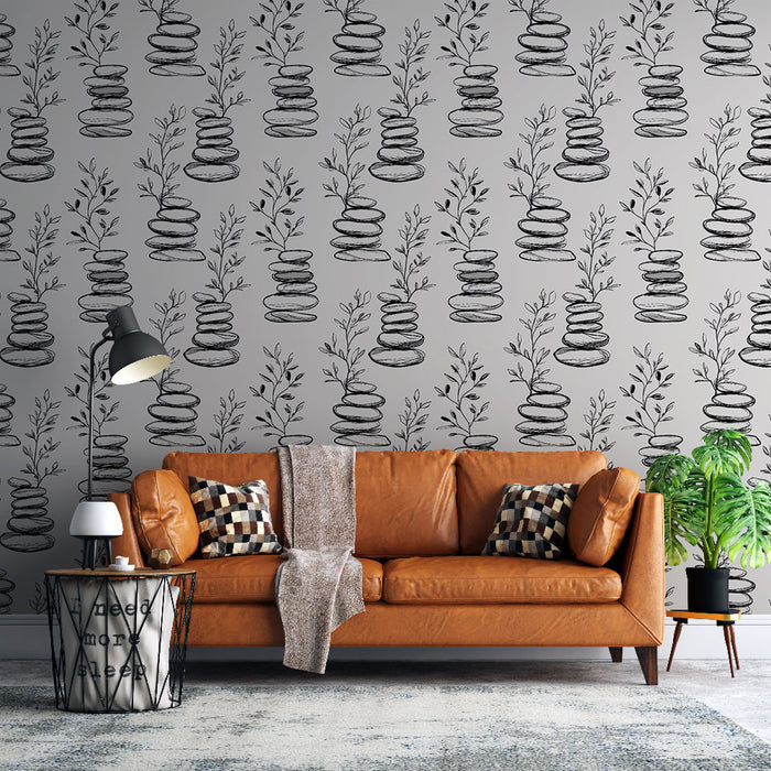 Un salon moderne avec un papier peint gris orné de motifs de pierres empilées et de feuillages délicats, créant une ambiance apaisante et naturelle.