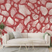 Un salon moderne avec un papier peint rouge aux motifs abstraits de formes organiques crème, créant une atmosphère chaleureuse et dynamique.