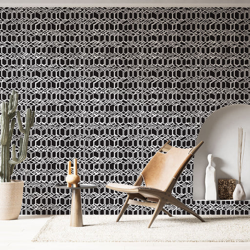 Un salon contemporain avec un papier peint géométrique noir et blanc aux motifs hexagonaux, créant une ambiance moderne et dynamique.