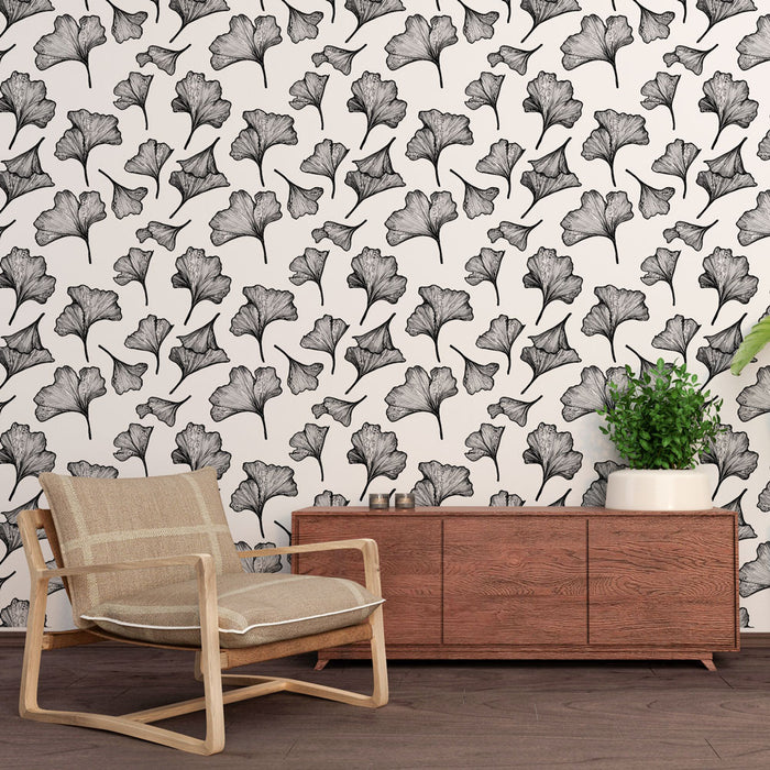 Une pièce moderne avec un papier peint floral en noir et blanc représentant des feuilles de ginkgo, créant une ambiance élégante et artistique.