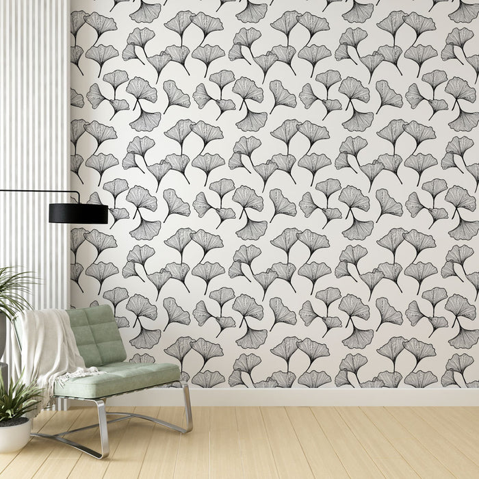 Une pièce moderne avec un papier peint délicat représentant des feuilles de ginkgo en noir sur fond blanc, créant une atmosphère élégante et apaisante.