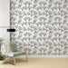 Une pièce moderne avec un papier peint délicat représentant des feuilles de ginkgo en noir sur fond blanc, créant une atmosphère élégante et apaisante.