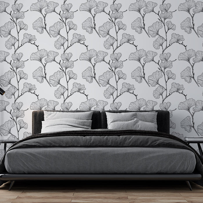 Une chambre moderne avec un papier peint représentant des motifs de feuilles de ginkgo en noir et blanc, créant une ambiance élégante et apaisante.