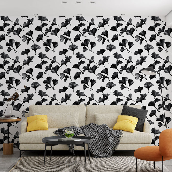Un salon moderne avec un papier peint noir et blanc aux motifs de feuilles de ginkgo, créant une atmosphère élégante et artistique.