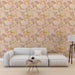 Un salon contemporain avec un papier peint floral aux motifs de feuilles de ginkgo dans des teintes douces de rose et doré, créant une atmosphère chaleureuse et élégante.