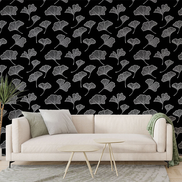 Un salon moderne avec un papier peint noir orné de délicates feuilles de ginkgo blanches, créant une ambiance élégante et contemporaine.