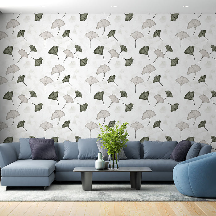Un salon moderne avec un papier peint aux motifs de feuilles de ginkgo dans des teintes vertes et grises sur fond clair, créant une atmosphère apaisante et naturelle.