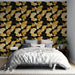 Une chambre moderne avec un papier peint floral noir, jaune et crème, présentant des feuilles stylisées qui apportent une ambiance dynamique et chaleureuse.