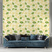 Un salon élégant avec un papier peint aux motifs de feuilles de ginkgo vertes et jaunes sur fond crème, dégageant une atmosphère fraîche et naturelle.