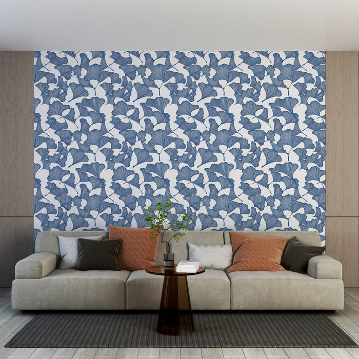 Un salon moderne avec un papier peint floral bleu représentant des feuilles de ginkgo sur fond blanc, créant une ambiance fraîche et apaisante.