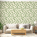 Un salon lumineux avec un papier peint floral vert clair représentant des feuilles de ginkgo sur fond beige, créant une atmosphère naturelle et apaisante.