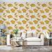 Un salon moderne avec un papier peint aux motifs de feuilles de ginkgo dorées sur fond crème, créant une atmosphère élégante et chaleureuse.