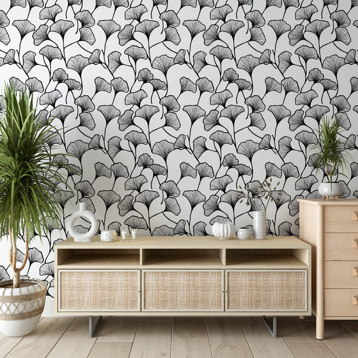 Une pièce moderne avec un papier peint aux motifs de feuilles de ginkgo en noir sur fond blanc, créant une ambiance élégante et apaisante.