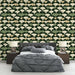 Une chambre moderne avec un papier peint aux motifs de feuilles stylisées dans des teintes vertes et crème sur fond sombre, créant une ambiance élégante et apaisante.