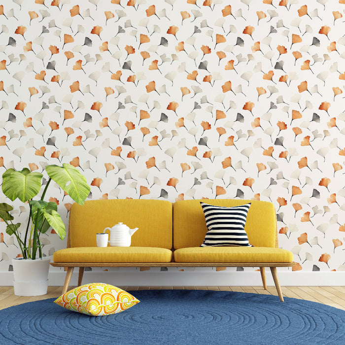 Un salon lumineux avec un papier peint aux motifs de feuilles délicates dans des teintes d'orange, beige et gris sur fond clair, créant une ambiance chaleureuse et accueillante.