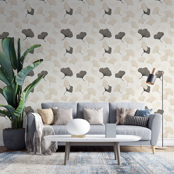 Un salon moderne avec un papier peint aux motifs de feuilles de ginkgo en beige et noir sur fond clair, créant une atmosphère élégante et apaisante.