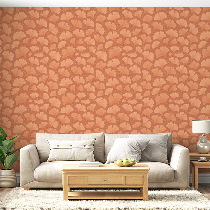 Un salon accueillant avec un papier peint terracotta orné de motifs de feuilles délicates, créant une atmosphère chaleureuse et naturelle.