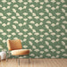 Une chambre lumineuse avec un papier peint vert sauge orné de motifs de feuilles de ginkgo blanches, créant une atmosphère naturelle et apaisante.