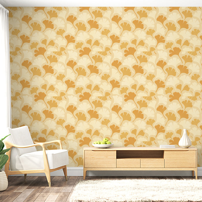 Un salon lumineux avec un papier peint aux motifs de feuilles ginkgo dans des teintes de jaune et beige, créant une ambiance chaleureuse et accueillante.