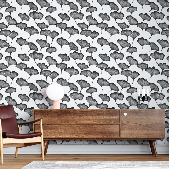 Une pièce moderne avec un papier peint noir et blanc représentant des feuilles de ginkgo, créant une ambiance élégante et artistique.