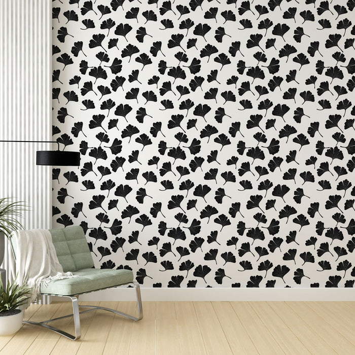 Un salon moderne avec un papier peint noir et blanc aux motifs de feuilles de ginkgo, créant une atmosphère élégante et contemporaine.