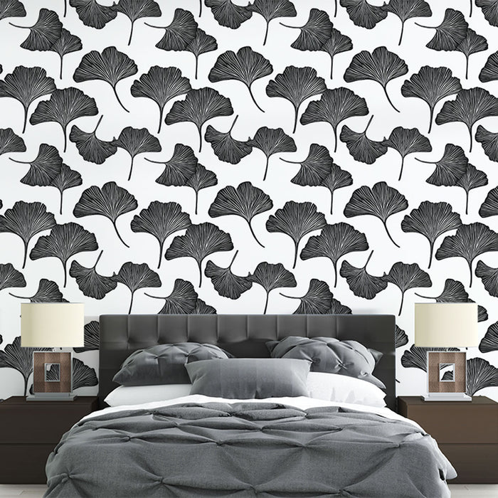 Une chambre moderne avec un papier peint représentant des feuilles de ginkgo en noir sur fond blanc, créant une atmosphère élégante et apaisante.