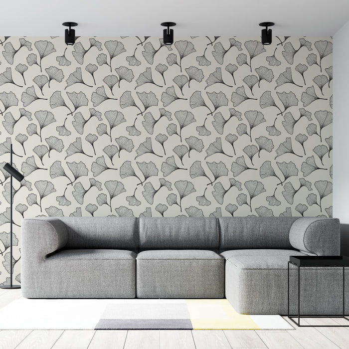 Un salon moderne avec un papier peint aux motifs de feuilles de ginkgo en noir sur fond clair, créant une ambiance élégante et apaisante.