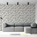 Un salon moderne avec un papier peint aux motifs de feuilles de ginkgo en noir sur fond clair, créant une ambiance élégante et apaisante.