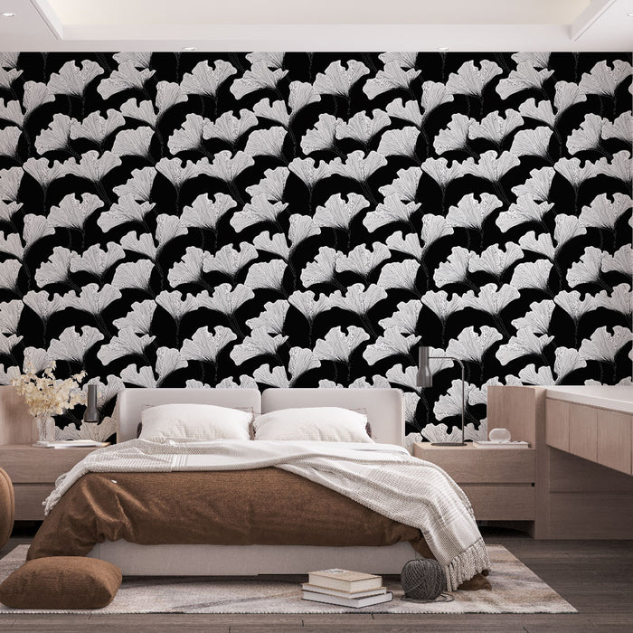 Une chambre moderne avec un papier peint floral noir et blanc représentant des feuilles de ginkgo, créant une ambiance élégante et artistique.