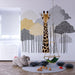 Une chambre d'enfant avec un papier peint illustrant une girafe souriante entourée d'arbres stylisés aux teintes douces de gris et de jaune, créant une ambiance ludique et chaleureuse.