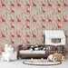 Une chambre d’enfant avec un papier peint illustrant des girafes stylisées en rouge sur un fond beige, créant une ambiance ludique et chaleureuse.